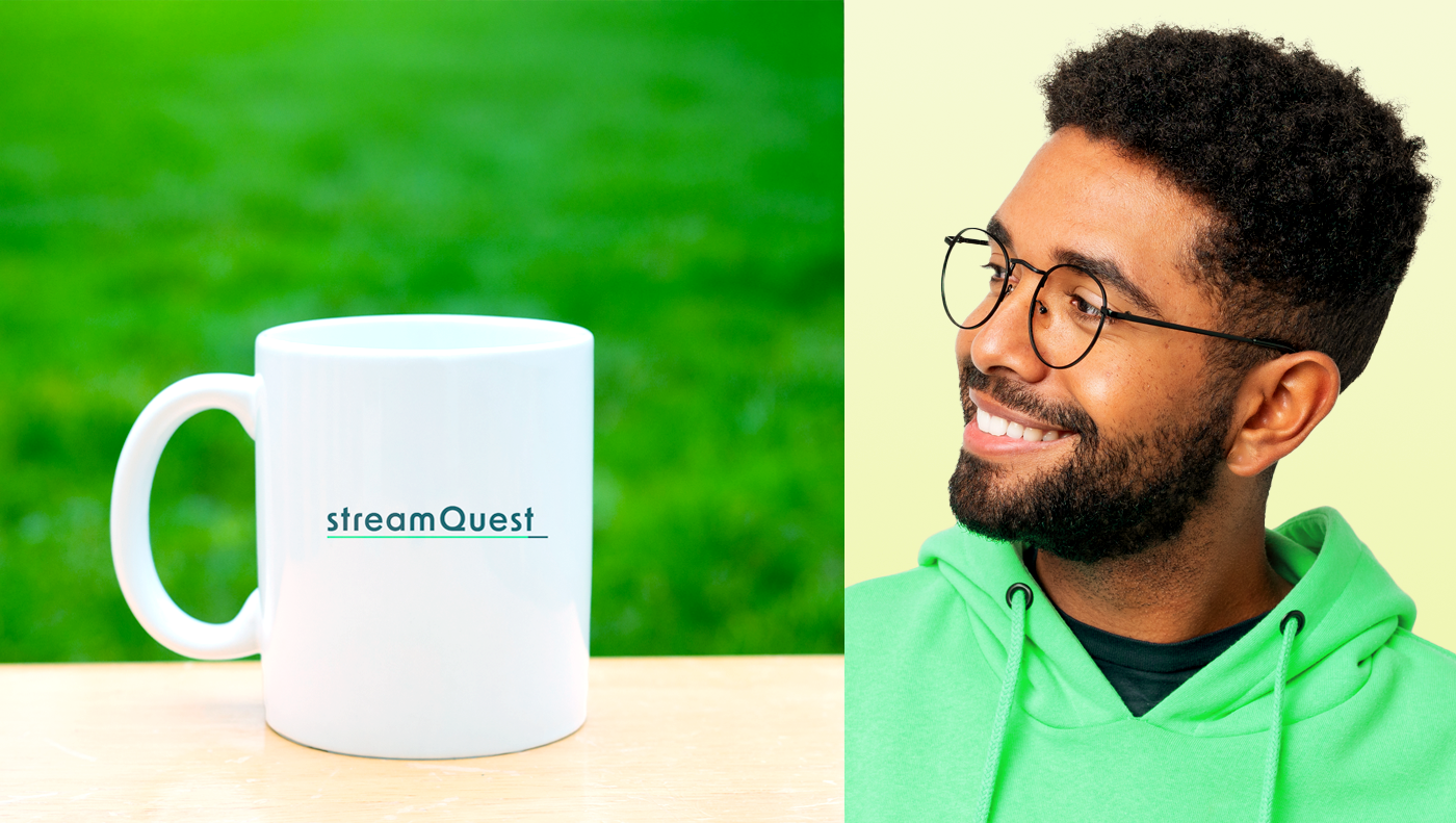 Mug with streamquest logo on it and smiling guy with green hoodie on